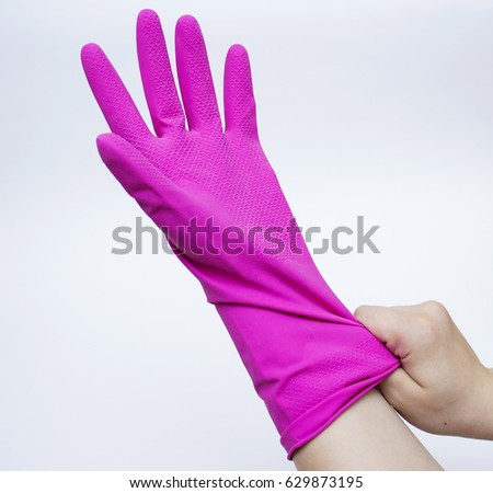 A young adult man's right hand stretching a disposable blue latex glove on his left hand. Isolated on white background.