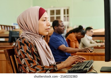 Young adult Middle Eastern woman wearing hijab working on computer in university library - Shutterstock ID 2160232383