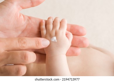 Young adult mother finger applying white moisturizing cream on newborn hand. Care about baby clean and soft body skin. Closeup. - Powered by Shutterstock