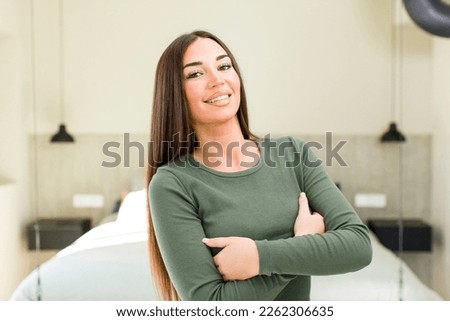 young adult pretty woman laughing happily with arms crossed, with a relaxed, positive and satisfied pose