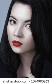 Young adult sexy lady with white skin red lips and black straight hairstyle. Mixed race Caucasian Asian female model isolated on gray background