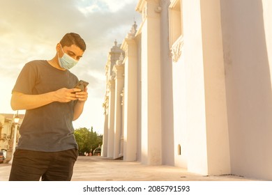 Young adult sightseeing outside a church with his smartphone texting and taking photos in a tourist spot in León, Nicaragua.