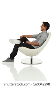 Young Adult Sitting And Leaning Back On Modern Chair Side View