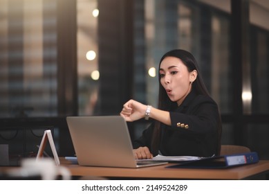 Young adult smart asian business woman in black casual suit using laptop working overtime in urban office. - Shutterstock ID 2149524289