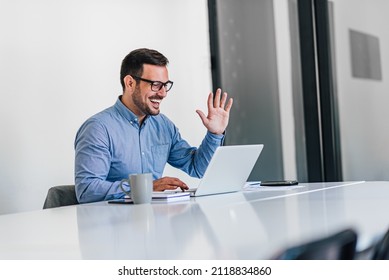 Young adult smiling cheerful businessman entrepreneur in modern bright office on online video conference call meeting greeting welcoming colleagues or partners - Powered by Shutterstock