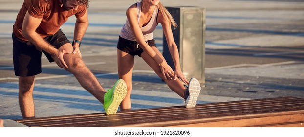 Young adult sporty couple working out outdoors in urban surroundings.