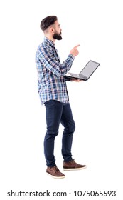 Young Adult Stylish Business Man With Laptop Pointing Finger At Presentation Looks Up. Full Body Isolated On White Background.