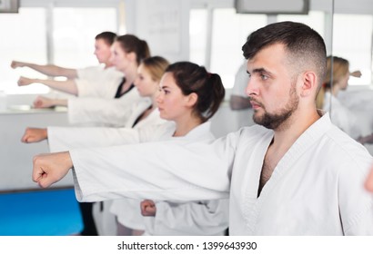 Young Adult Trainees Practicing Of New Maneuvers In The Karate Class 