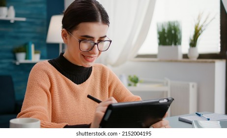 Young Adult Using Digital Tablet With Stylus To Do Remote School Work, Learning Assignment Knowledge At Home. Student Working On Device For Online Class Lesson, Dping Research And Taking Notes.