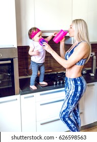 Young adult woman in 30s using protein shaker and baby food bottle with her baby daughter. Authentic people. Toned image.