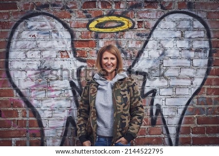 Young adult woman with angel wing on the wall
