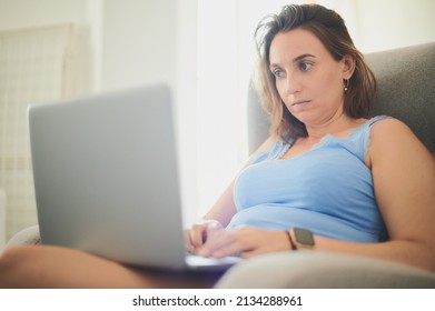 Young Adult Woman Casually Dressed Works From Home Solving Problems With A Laptop. Real People Concept.