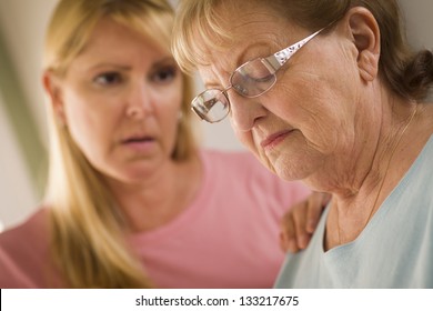 Young Adult Woman Consoles Sad Senior Adult Female.