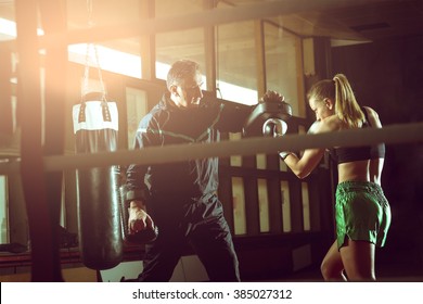 Young Adult Woman Doing Kickboxing Training With Her Coach.