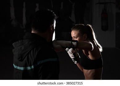 Young Adult Woman Doing Kickboxing Training With Her Coach.