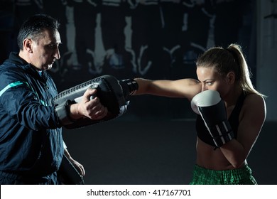 Young Adult Woman Doing Kickboxing Training With Her Coach.