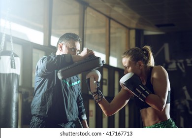 Young Adult Woman Doing Kickboxing Training With Her Coach.