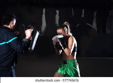 Young Adult Woman Doing Kickboxing Training With Her Coach.