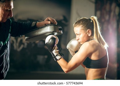 Young Adult Woman Doing Kickboxing Training With Her Coach.