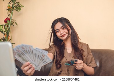 Young Adult Woman Entrepreneur Business Maker Flashing Cash Money And Debit Cards From Income Online.