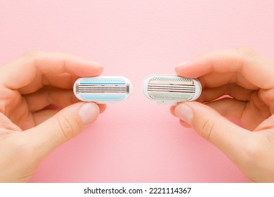 Young Adult Woman Hands Holding New And Old Razor Heads On Light Pink Table Background. Pastel Color. Compare Two Objects. Closeup. Point Of View Shot.