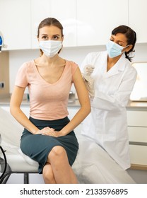 Young Adult Woman In Medical Face Mask Getting Vaccinated At Doctors Office, Coronavirus Or Flu Vaccination