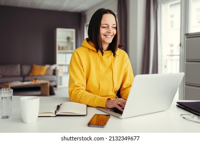 Young Adult Woman In Yellow Hoodie Type On Laptop. Remote Education
