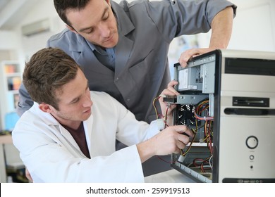 Young Adults Fixing Computer Hardware In Technology School