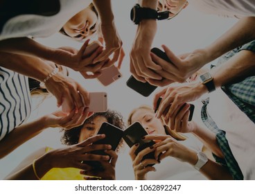 Young adults using smartphones in a circle social media and connection concept - Shutterstock ID 1062892247