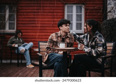 A young and affectionate couple sharing a warm moment over coffee on their home's outdoor patio with a relaxed ambiance. - Powered by Shutterstock