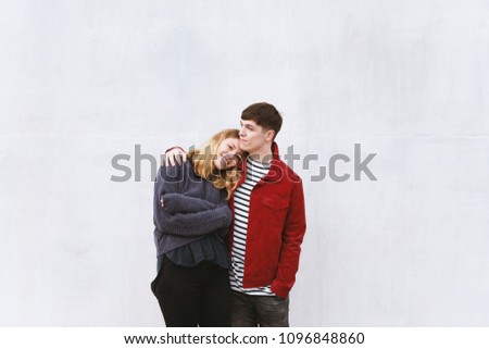 young couple in love in front of a concrete wall with free space for text