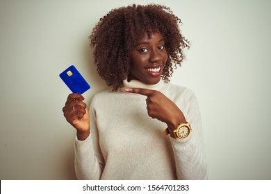 Young African Afro Woman Holding Credit Card Standing Over Isolated White Background Very Happy Pointing With Hand And Finger