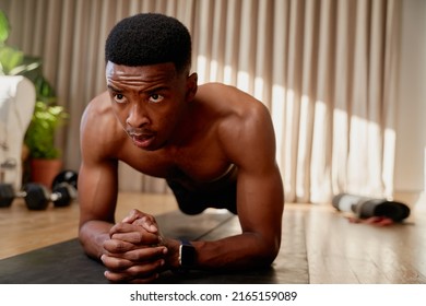 Young African American Black Male Exercising At Home Holding Plank Position, Working Out From Home On His Exercise Mat 