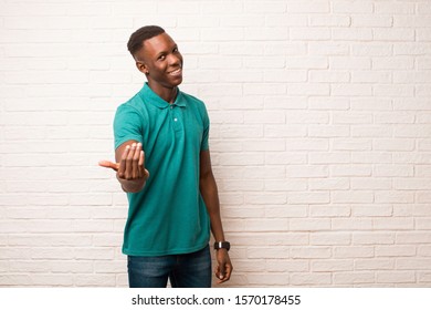 Young African American Black Man Feeling Happy, Successful And Confident, Facing A Challenge And Saying Bring It On! Or Welcoming You Against Brick Wall