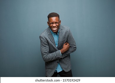 Young African American Black Man Feeling Anxious, Ill, Sick And Unhappy, Suffering A Painful Stomach Ache Or Flu Against Grunge Wall