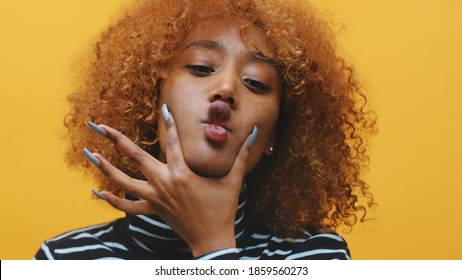 Young African American Black Woman With Curly Hair And Long Nails Making Grimaces . High Quality Photo