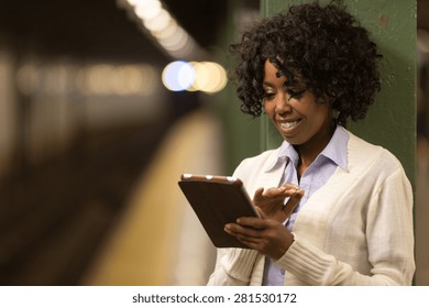 Young African American Black Woman Using Tablet Pc In Subway Station