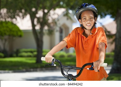 A Young African American Boy Child Riding Bicycle Or Bike In The Summer