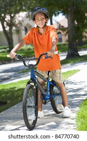 A Young African American Boy Child Riding Bicycle Or Bike In The Summer