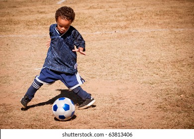 Young African American Boy Playing Soccer.