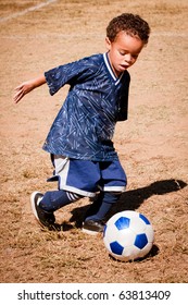 Young African American Boy Playing Soccer.