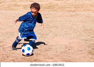 Young African American Boy Playing Soccer.