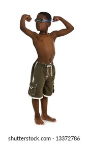 A Young African American Boy Wearing Swim Trunks And Goggles, And Showing His Muscles. Isolated On A White Background.