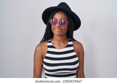 Young african american with braids wearing hat and sunglasses smiling looking to the side and staring away thinking.  - Shutterstock ID 2302419567