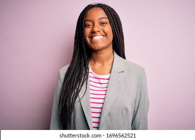 Young african american business woman standing over pink isolated background with a happy and cool smile on face. Lucky person. - Shutterstock ID 1696562521