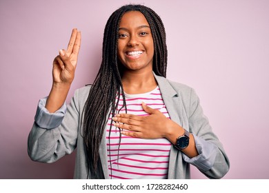 Young African American Business Woman Standing Over Pink Isolated Background Smiling Swearing With Hand On Chest And Fingers Up, Making A Loyalty Promise Oath