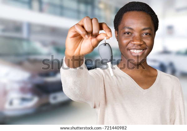 Young\
African American businessman holding a car\
key