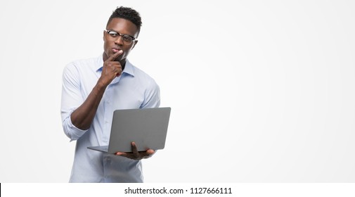 Young African American Businessman Using Computer Laptop Serious Face Thinking About Question, Very Confused Idea