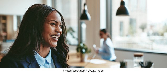 Young African American businesswoman laughing while walking in an office after a meeting with colleagues  - Powered by Shutterstock