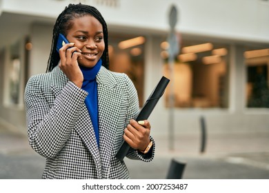 Young african american businesswoman smiling happy talking on the smartphone at the city. - Powered by Shutterstock